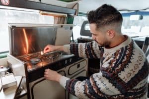 Camper van with hinged cover for stove and sink